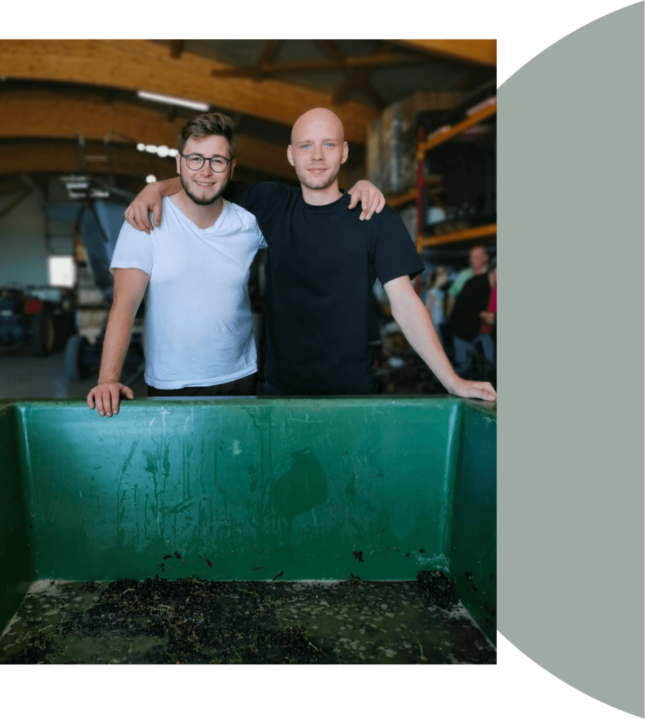 Christian und Martin vor gepressten Weintrauben